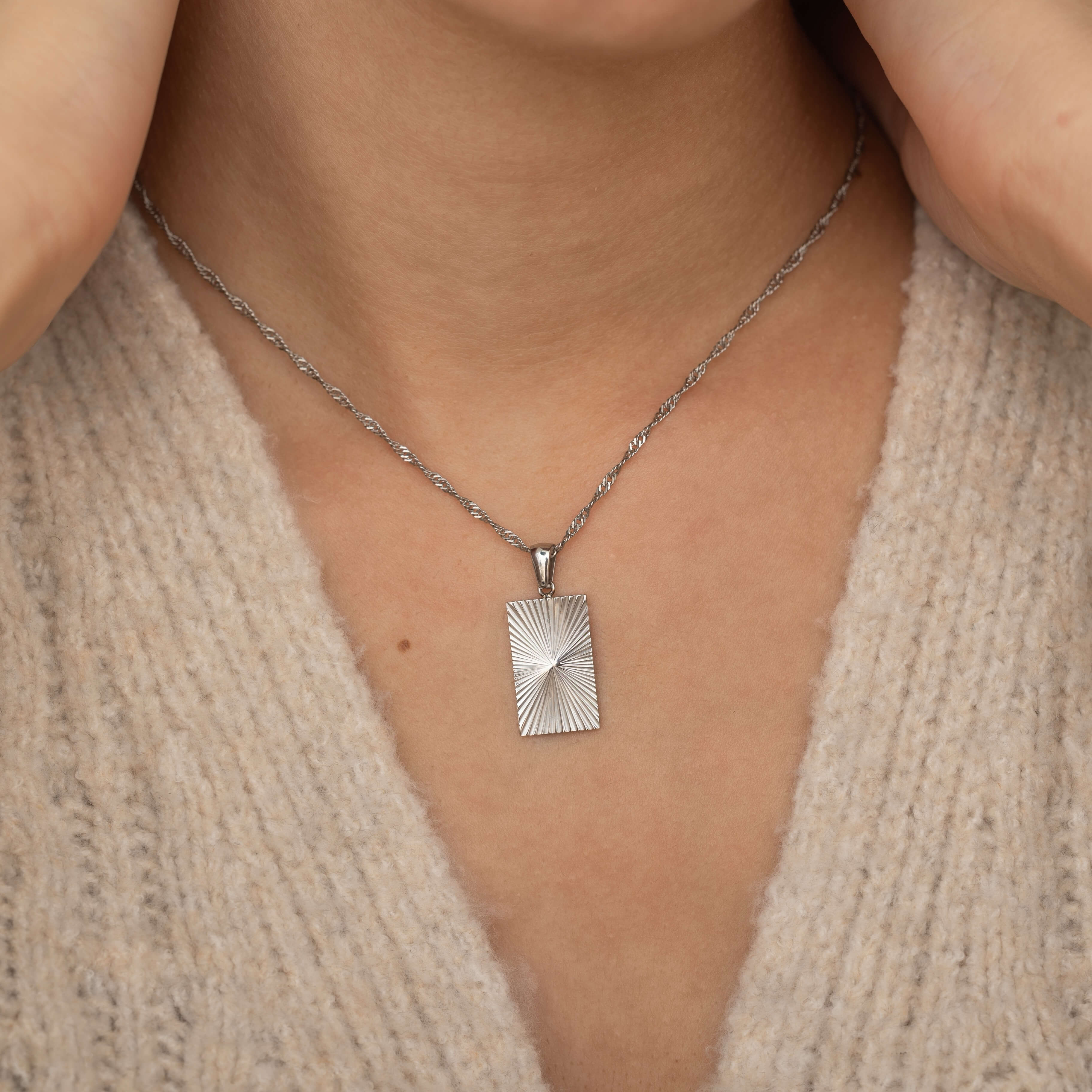rectangle sunburst necklace with an etched sunburst design on a rectangle pendant, symbolizing warmth and vitality, perfect for adding a touch of boho elegance.