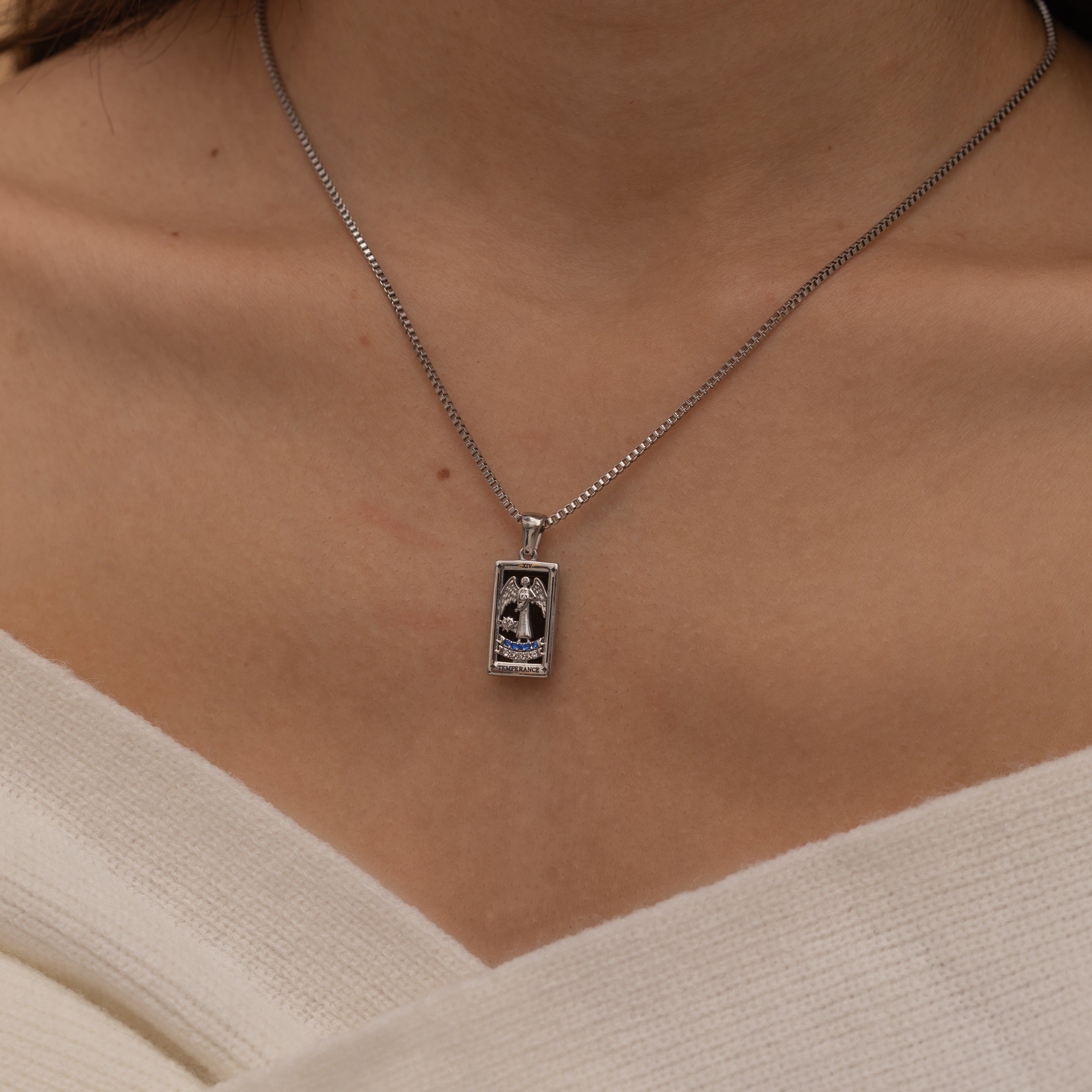 Silver Temperance tarot necklace with cubic zirconia accents and an onyx back stone, symbolizing balance and harmony.