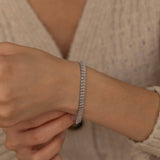   Gold and silver tennis bracelets side by side, each adorned with dazzling stones, ideal for versatile and stylish wear.