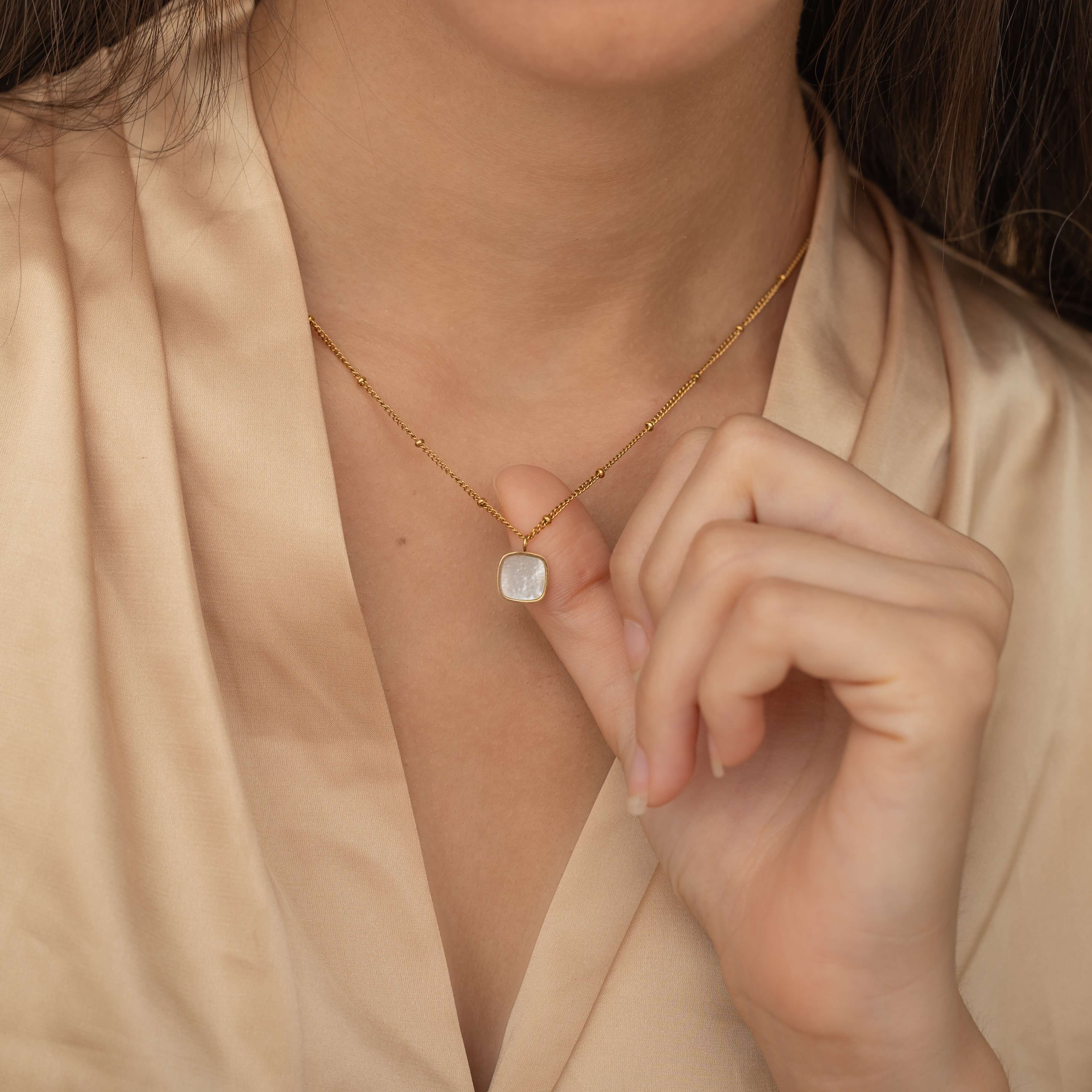 Square mother of pearl pendant with a gold frame on a gold chain
