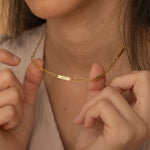 Gold necklace with multiple engraved name bar charms, personalized family name jewelry