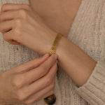 Gold mesh bracelet highlighting its elegant and versatile design, suitable for various occasions.