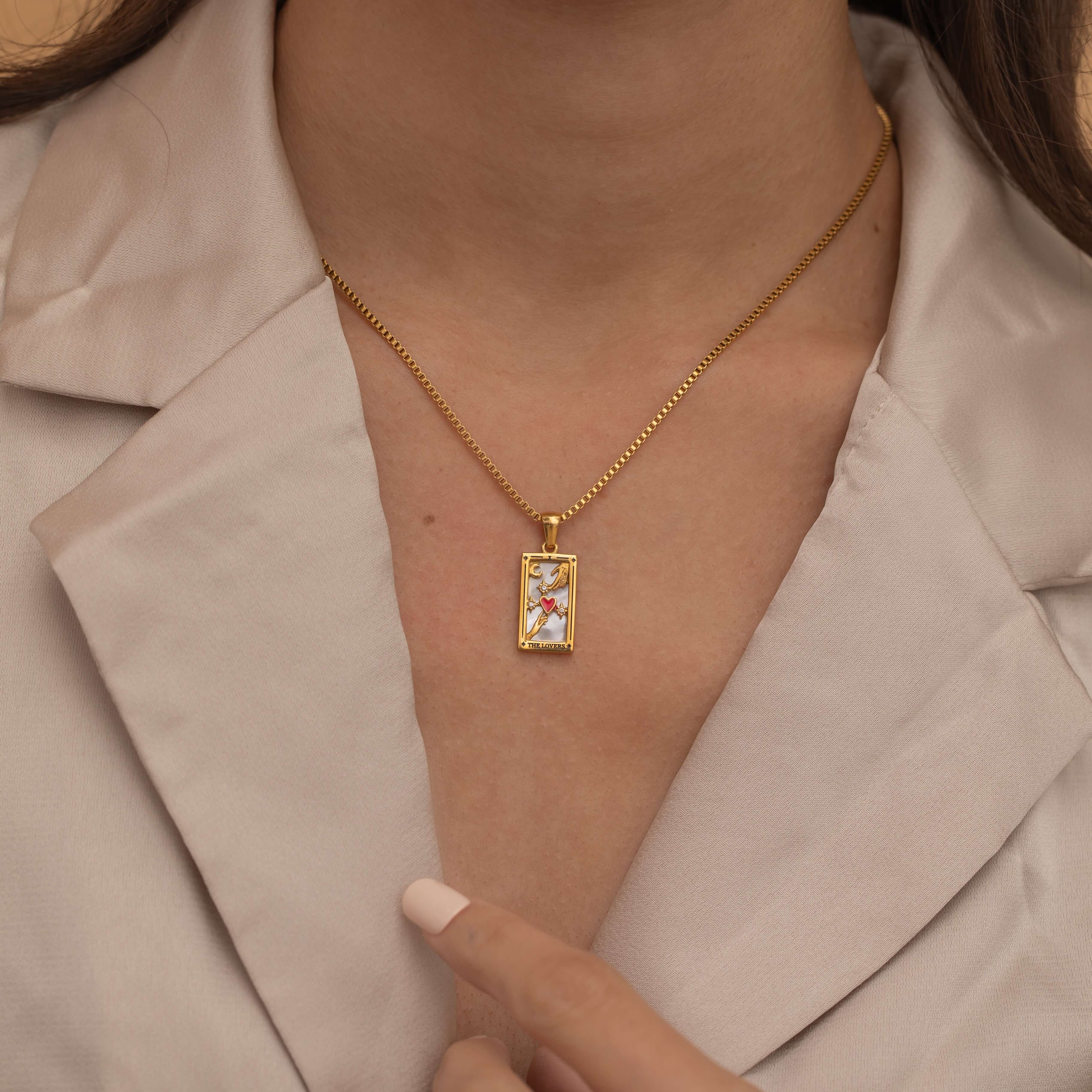 Gold the lovers tarot necklace with cubic zirconia accents and an mother of pearls back stone, symbolizing connection and unity